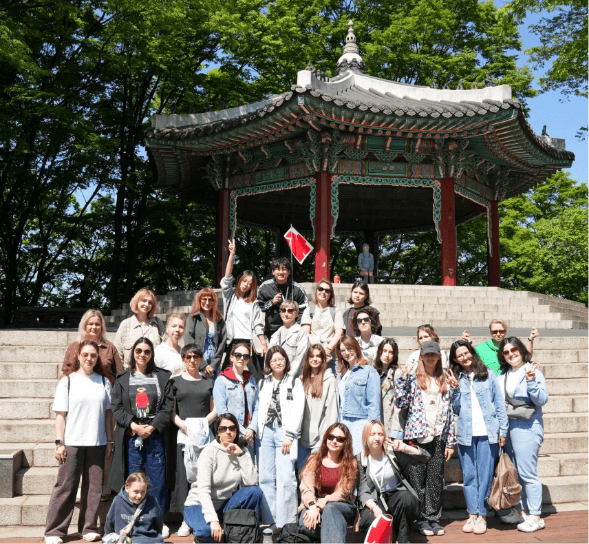 A group of travelers in front of a traditional pavilion