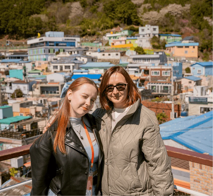 Two travelers against the backdrop of a colorful seaside neighborhood