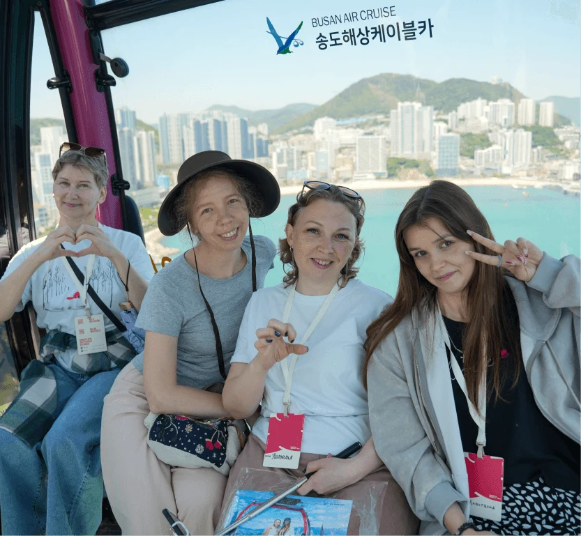 Four travelers in a cable car cabin overlooking the coast
