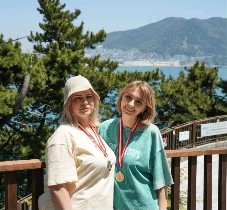 Two travelers with medals against the sea