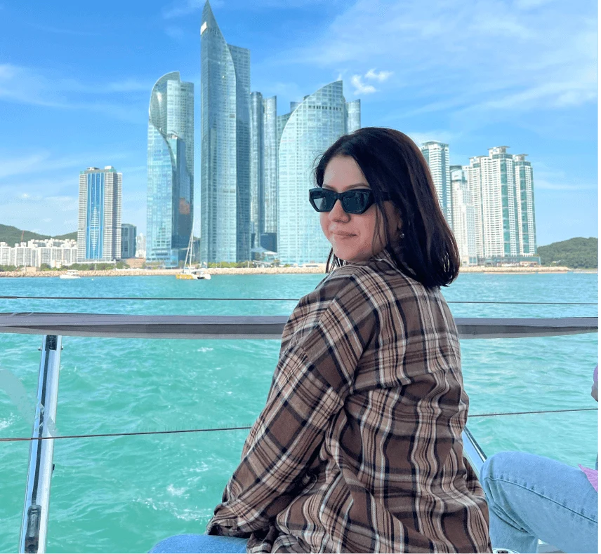 A traveler on a boat against a backdrop of modern skyscrapers