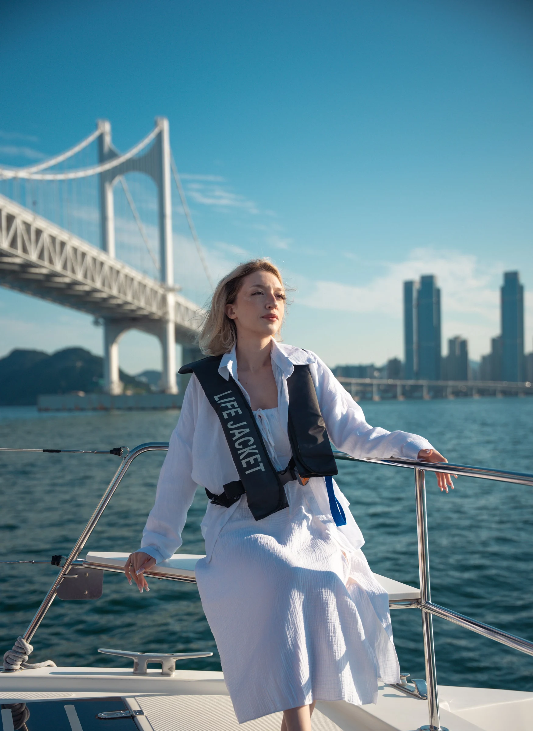 A traveler on a boat with a bridge and skyscrapers in the background
